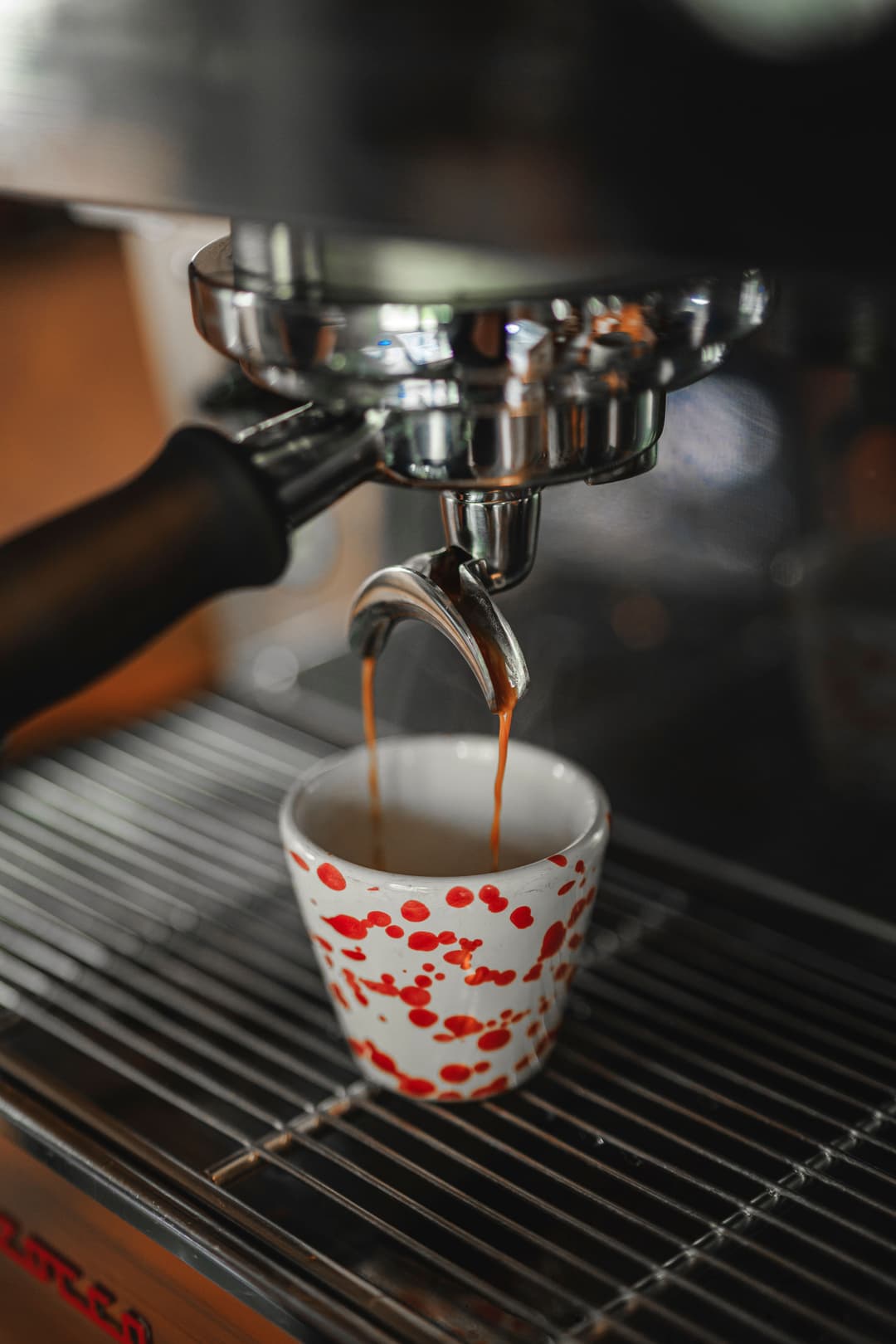 Espressomachine, espresso dripping in dotted cup