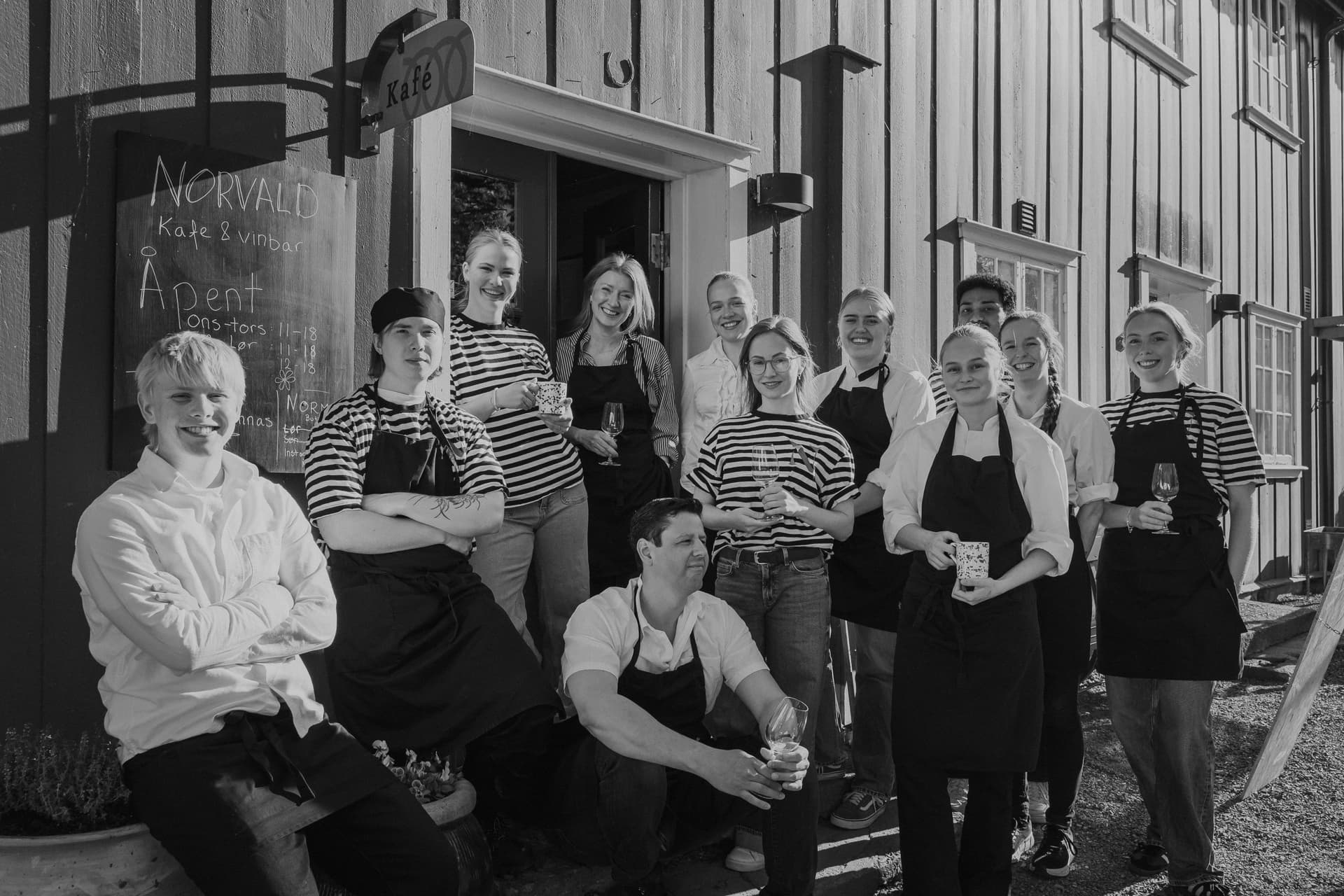 Cafe staff outside cosy cafe smiling