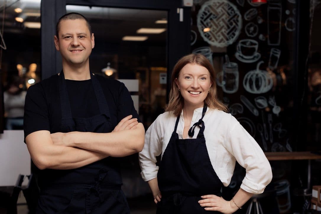 Smiling staff in uniform outside shop or cafe