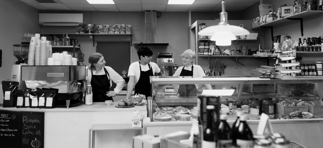Cafe staff behind counter black and white. cheese shop
